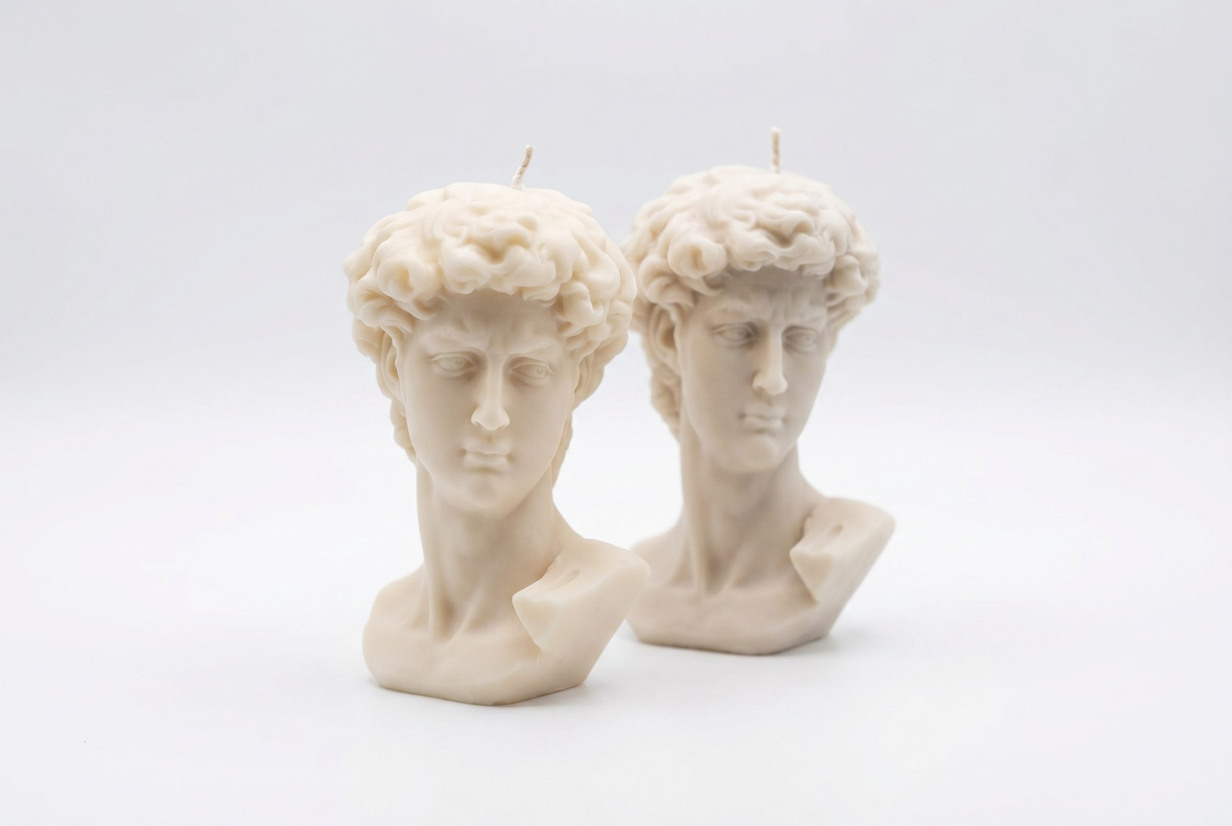 Clean Fotogenic AI studio output showing sculptural bust candles on white backdrop