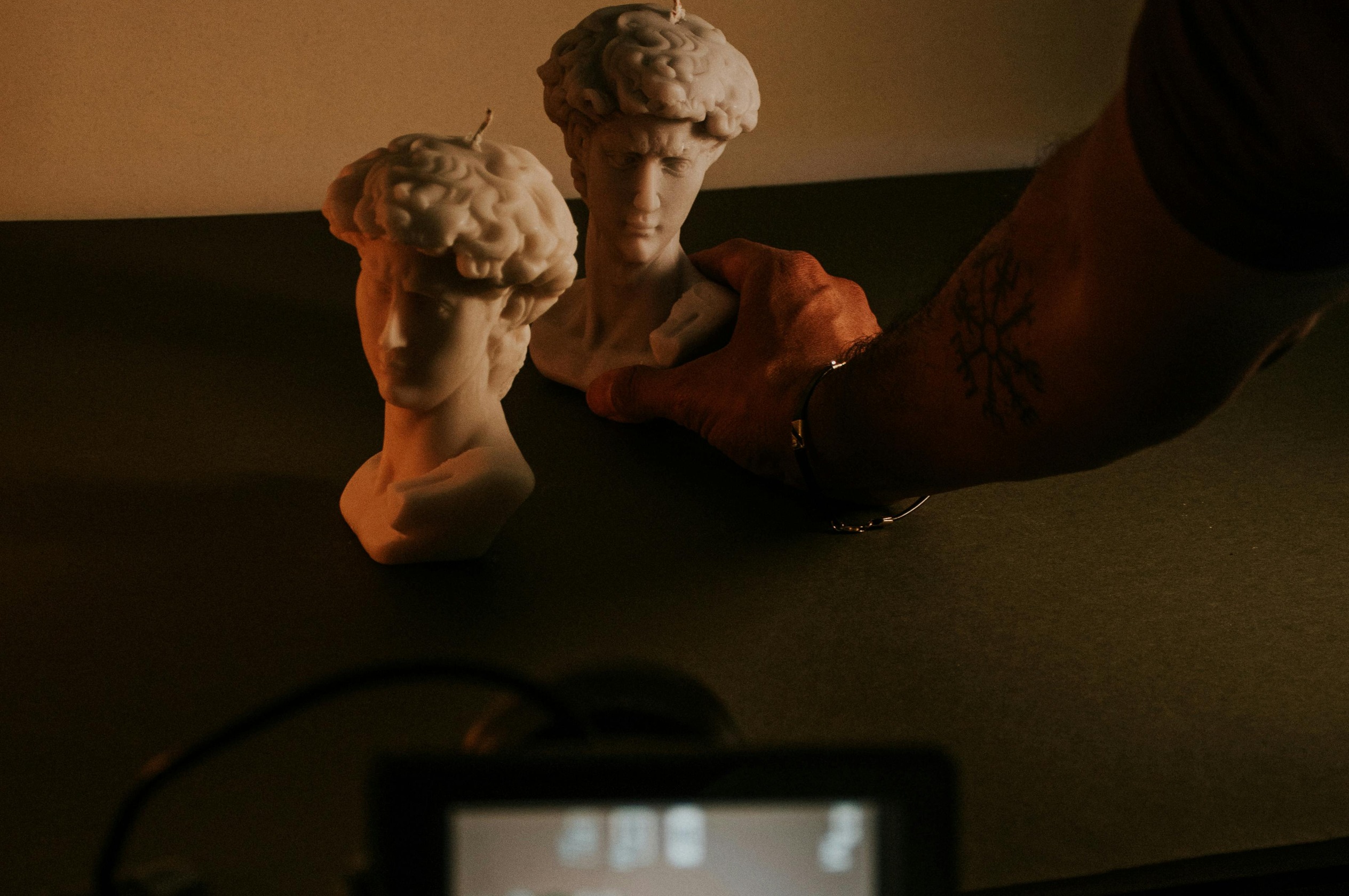 Stable phone capture of sculptural bust candles before Fotogenic AI lifestyle scene generation