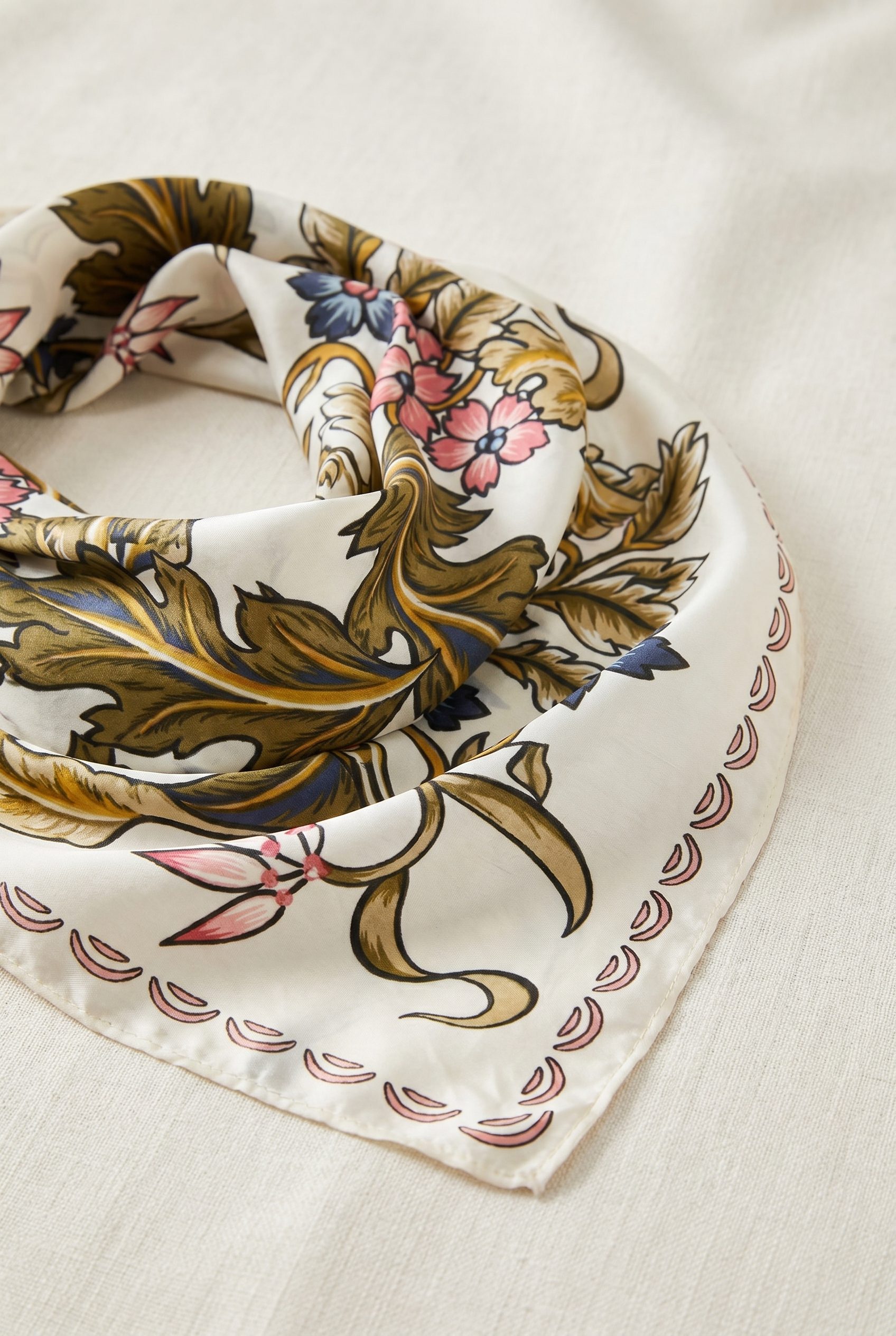 Fotogenic AI generated ecommerce accessories image of a green floral square scarf in a refined product scene