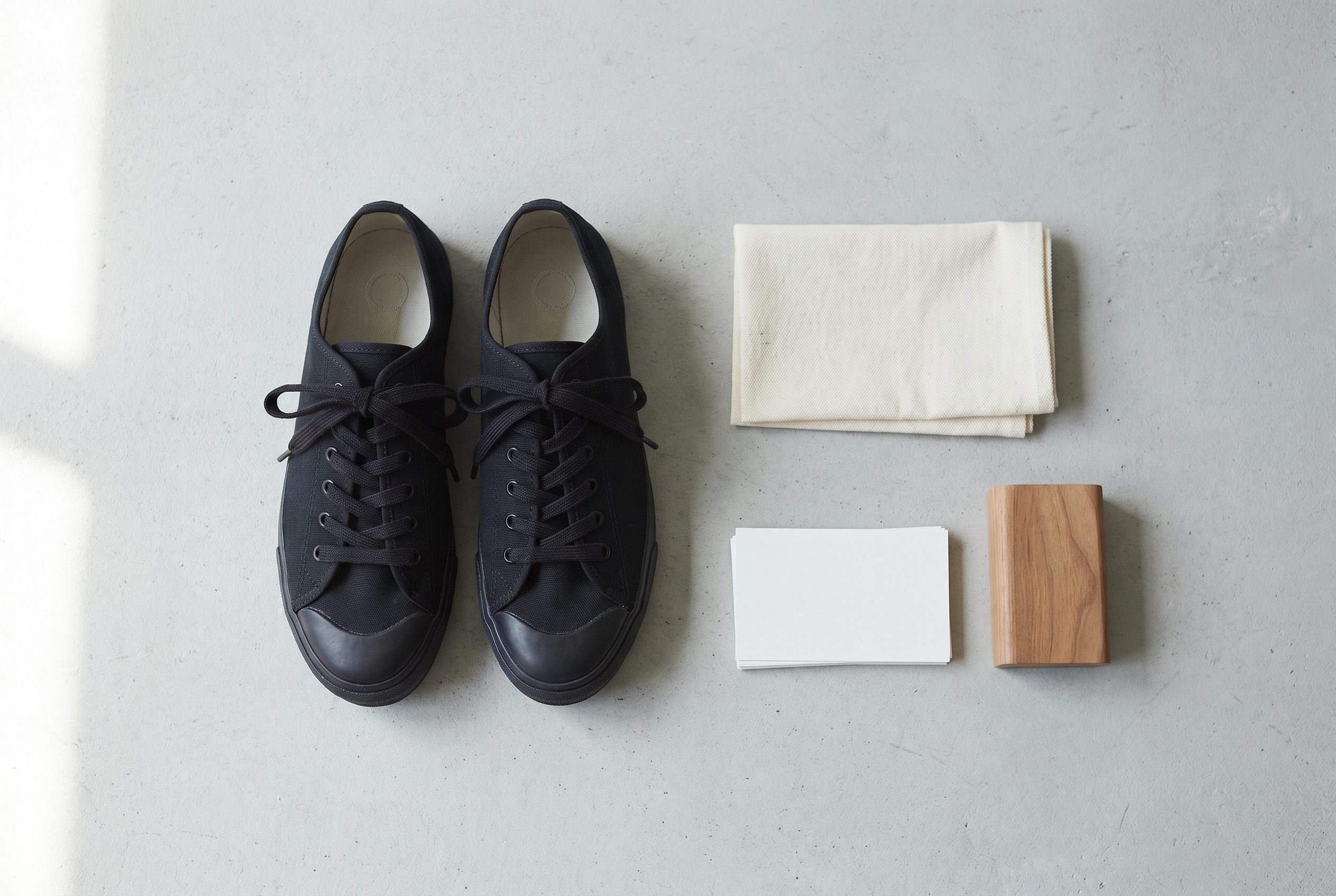 Fotogenic AI footwear social flat lay with black sneakers and clean ecommerce props