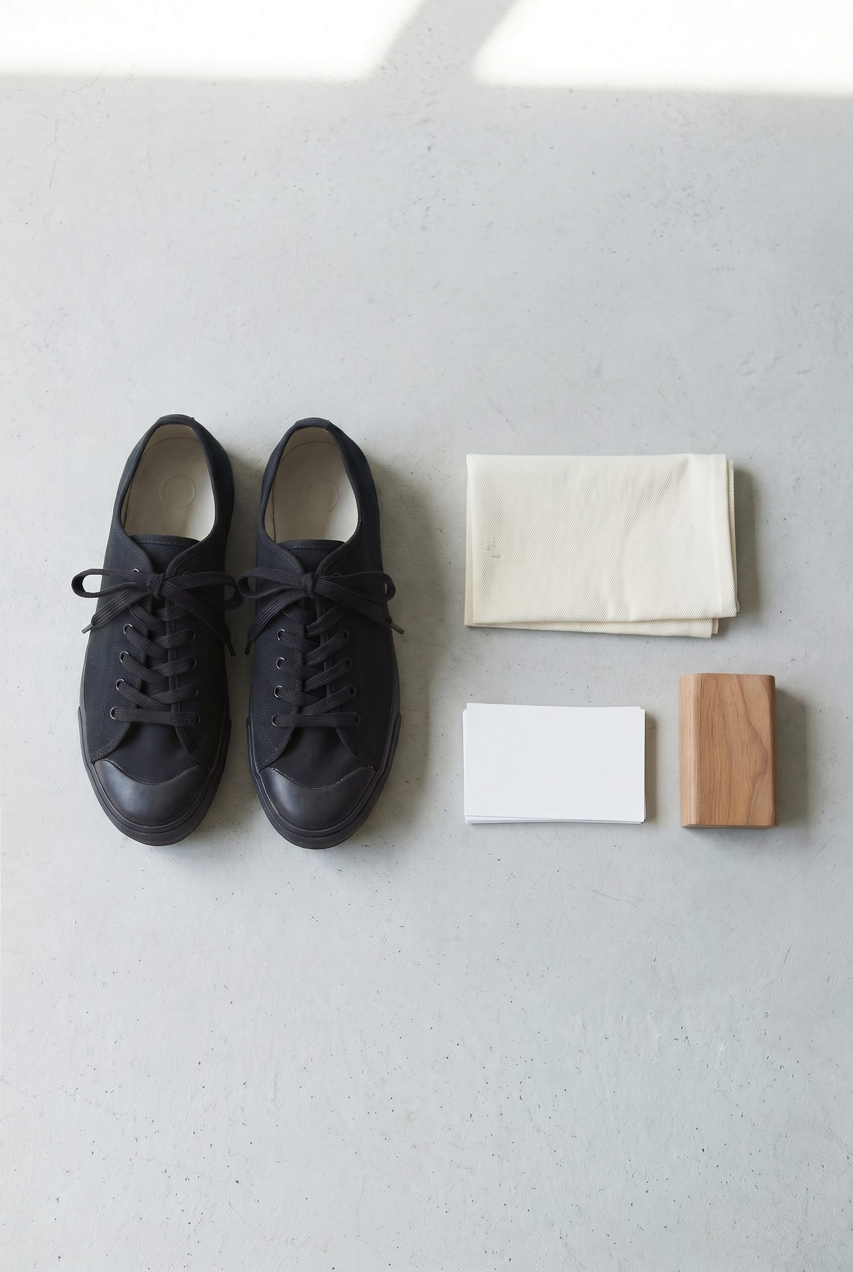 Black canvas sneakers in a vertical Pinterest-style footwear product photography pin