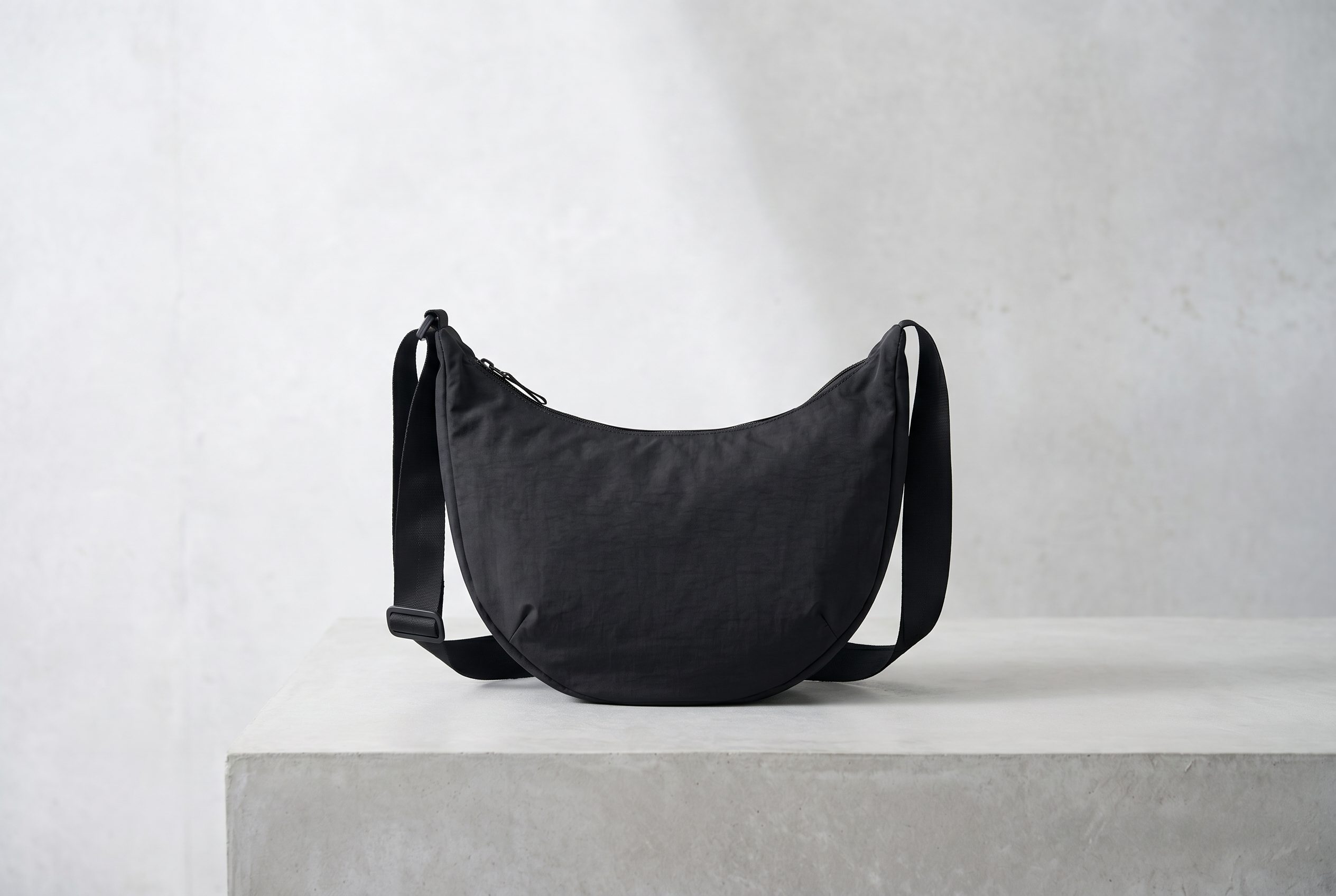 Bags product photography example of a black crescent shoulder bag fully visible in a clean 3:2 studio frame