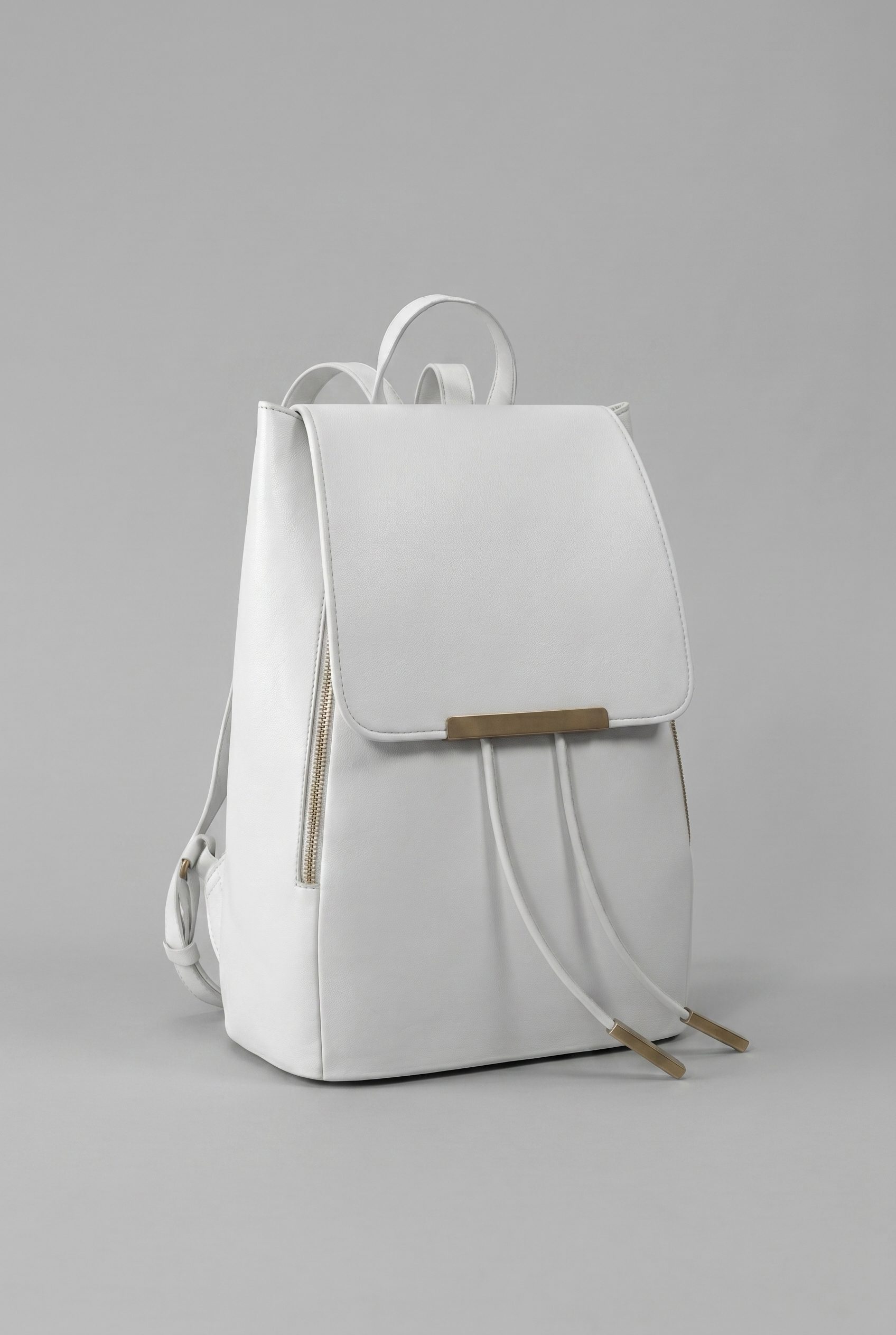 Bags product photography studio example of a white backpack upright against a neutral gray background