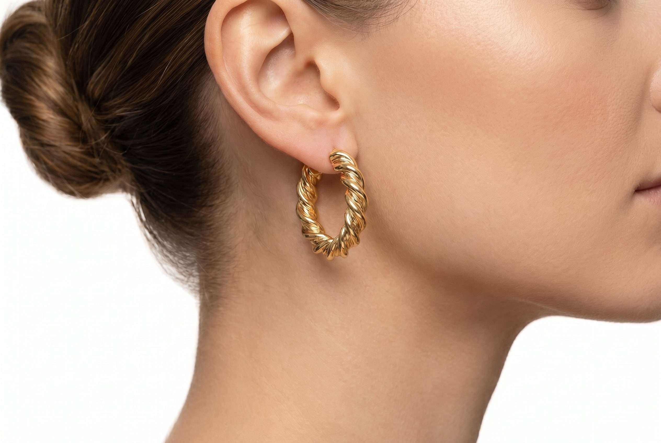 Gold hoop earrings worn on ear for jewelry social and feed-ready crops.