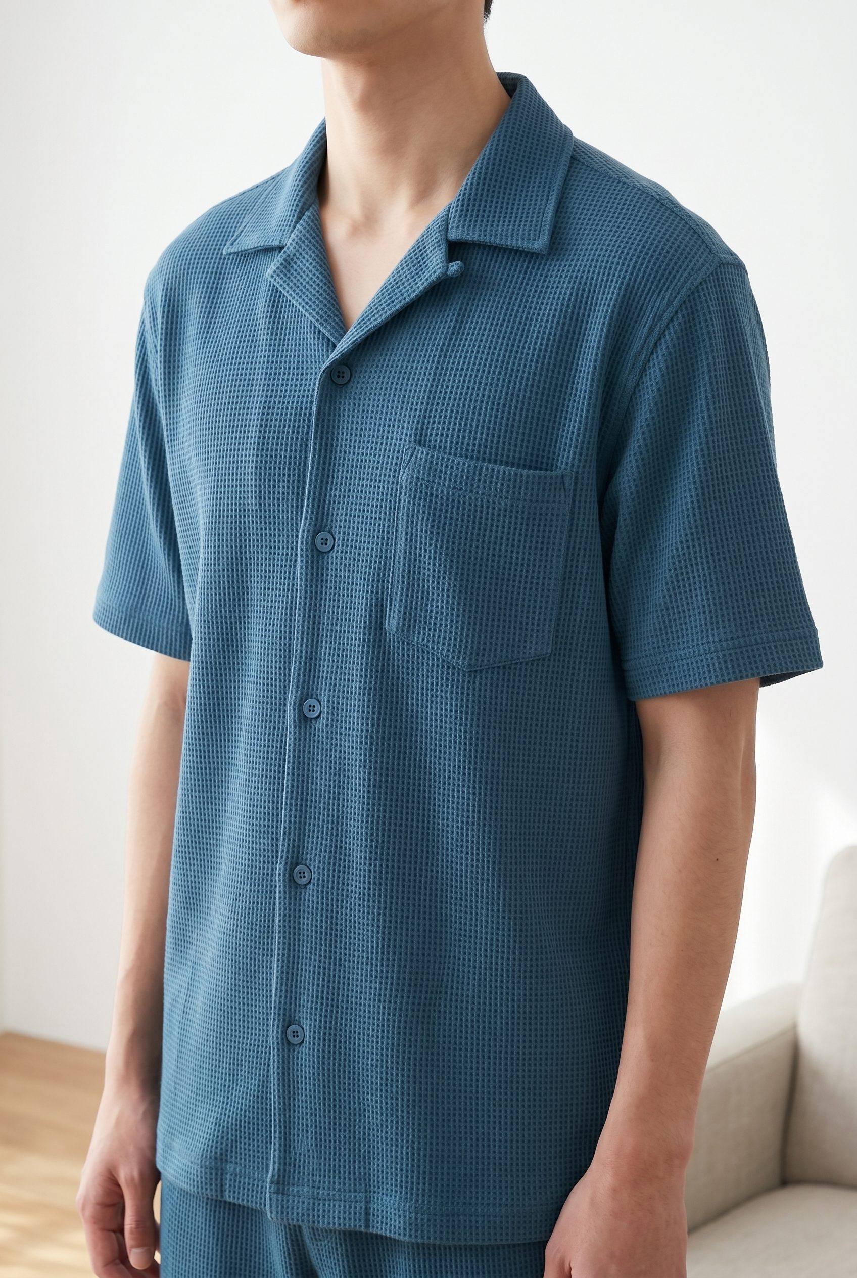 Blue short sleeve shirt styled on a model in a clean studio setting.