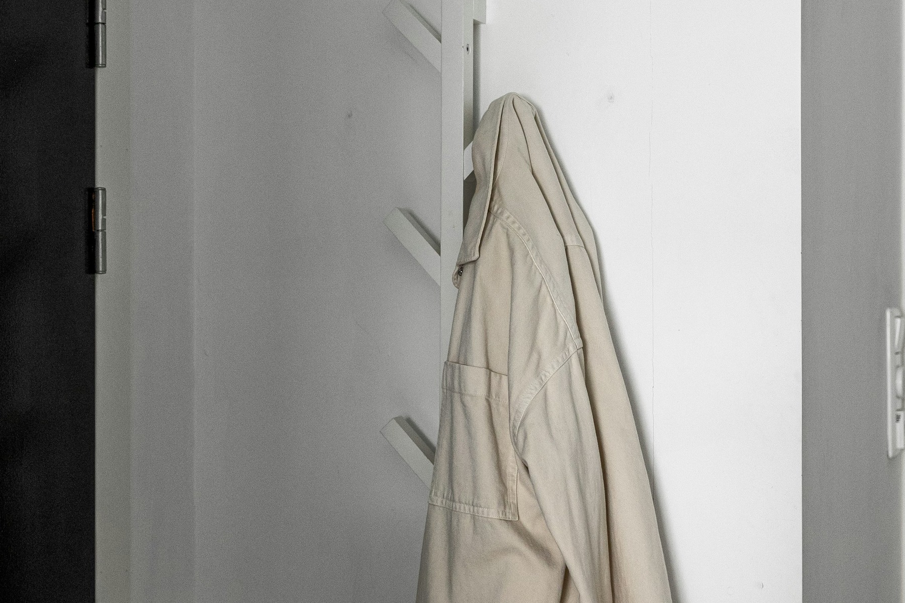 Lifestyle Product Photography before image showing coat on rack for outerwear look