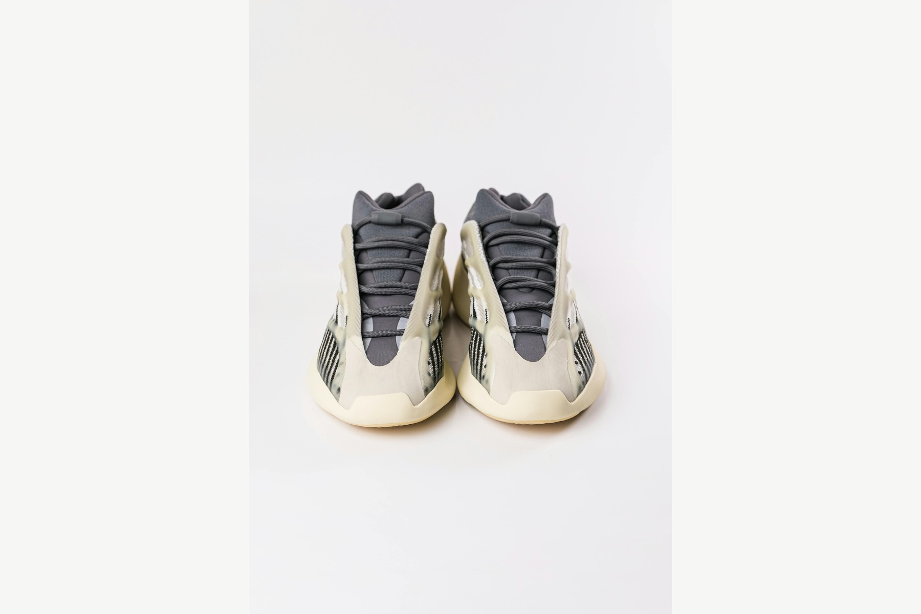 Lifestyle Product Photography before image showing no-logo athletic shoes on white background for sneaker setup
