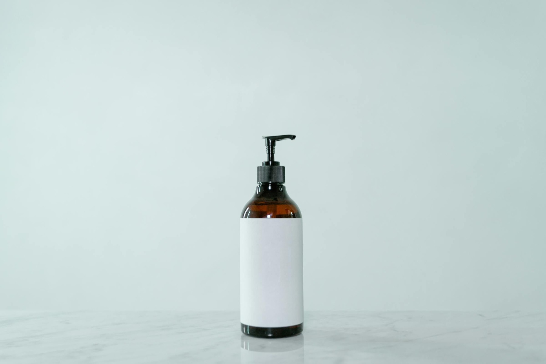 White Background Product Photos before image showing blank-label brown glass pump bottle for soap dispenser