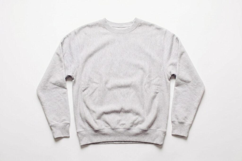 White sweatshirt laid flat against a pale background.