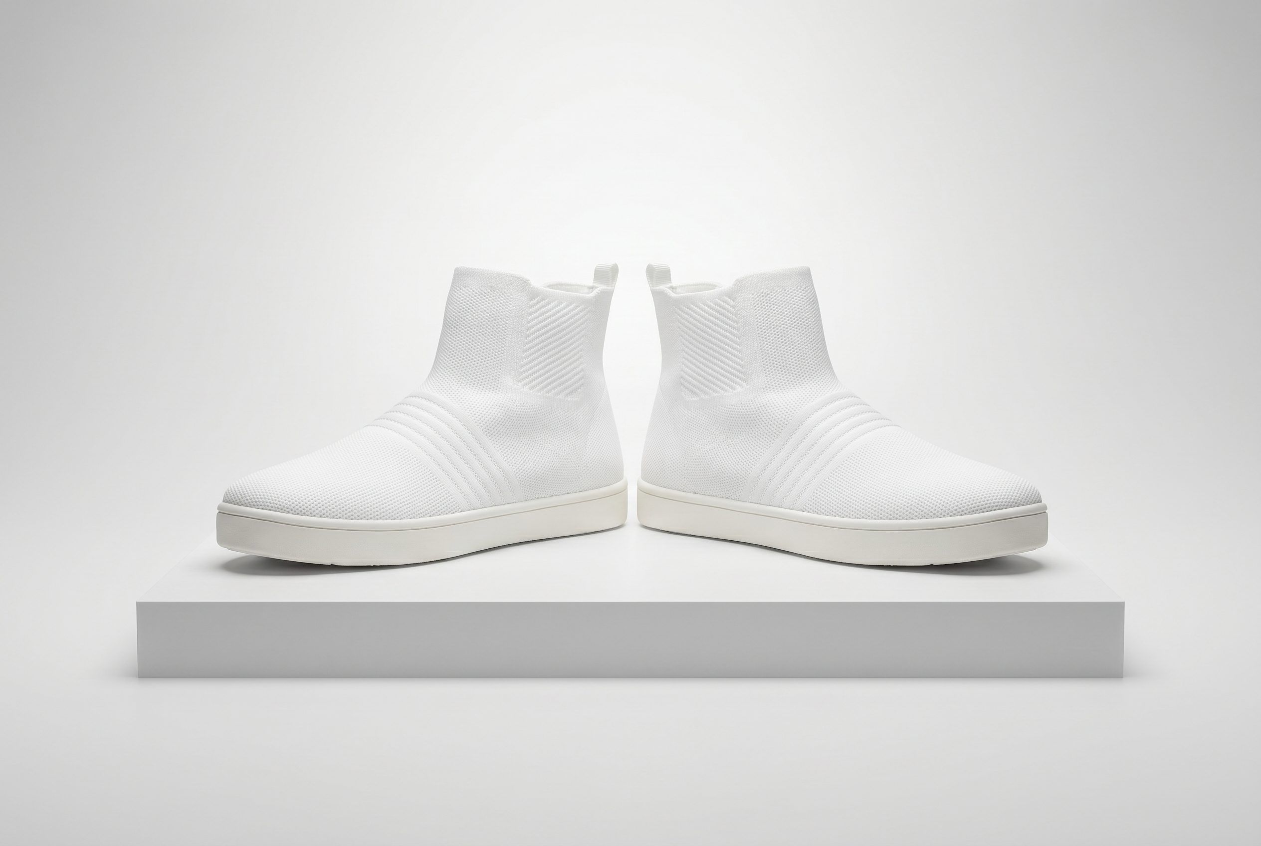 White knit sneakers in a clean studio footwear product photo