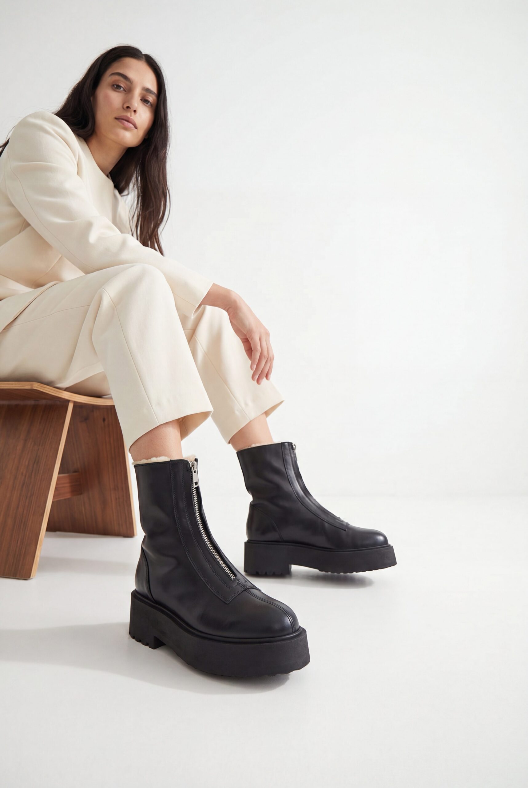 Black boot lifestyle product photo with a model, showing fit and scale for footwear ecommerce.