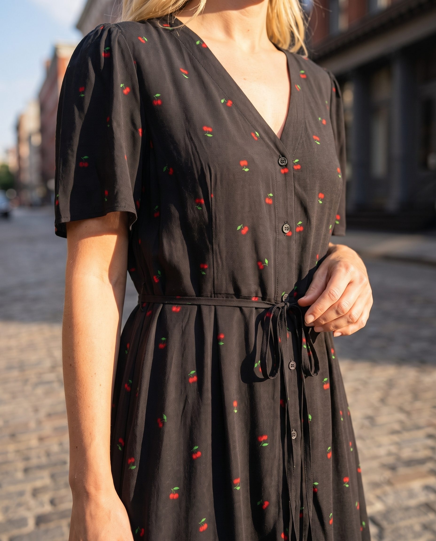 Black cherry print dress detail shown in a premium urban apparel campaign frame.