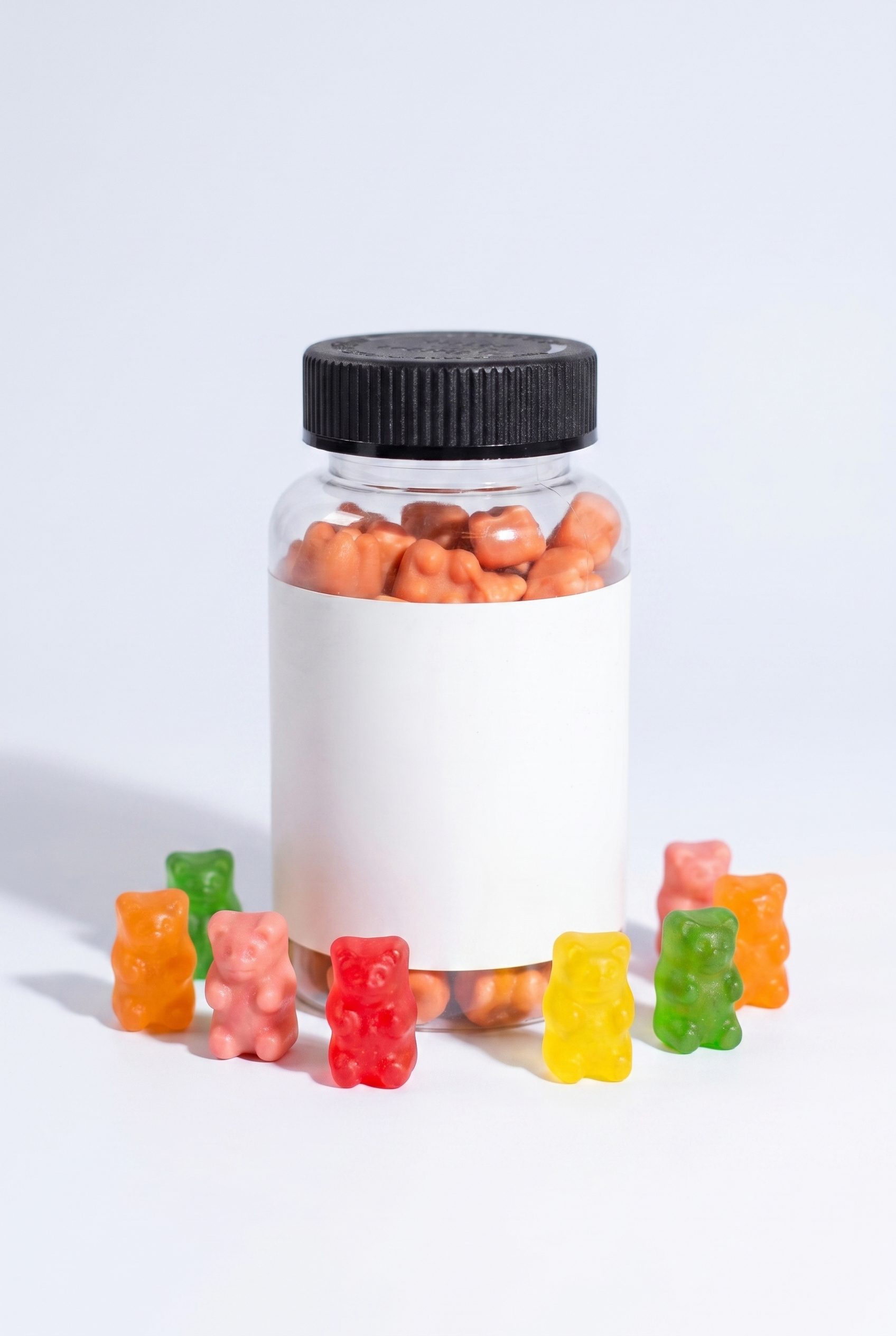 Vertical gummy vitamin jar hero image with colorful gummies and blank label for supplement ecommerce pages.
