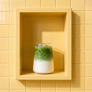 Iced matcha photographed against yellow tiles