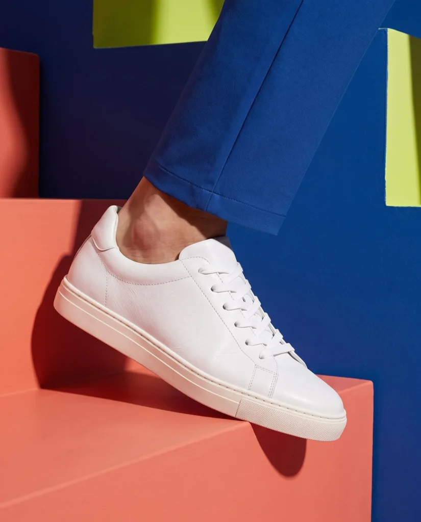 White sneaker worn on a coral stair