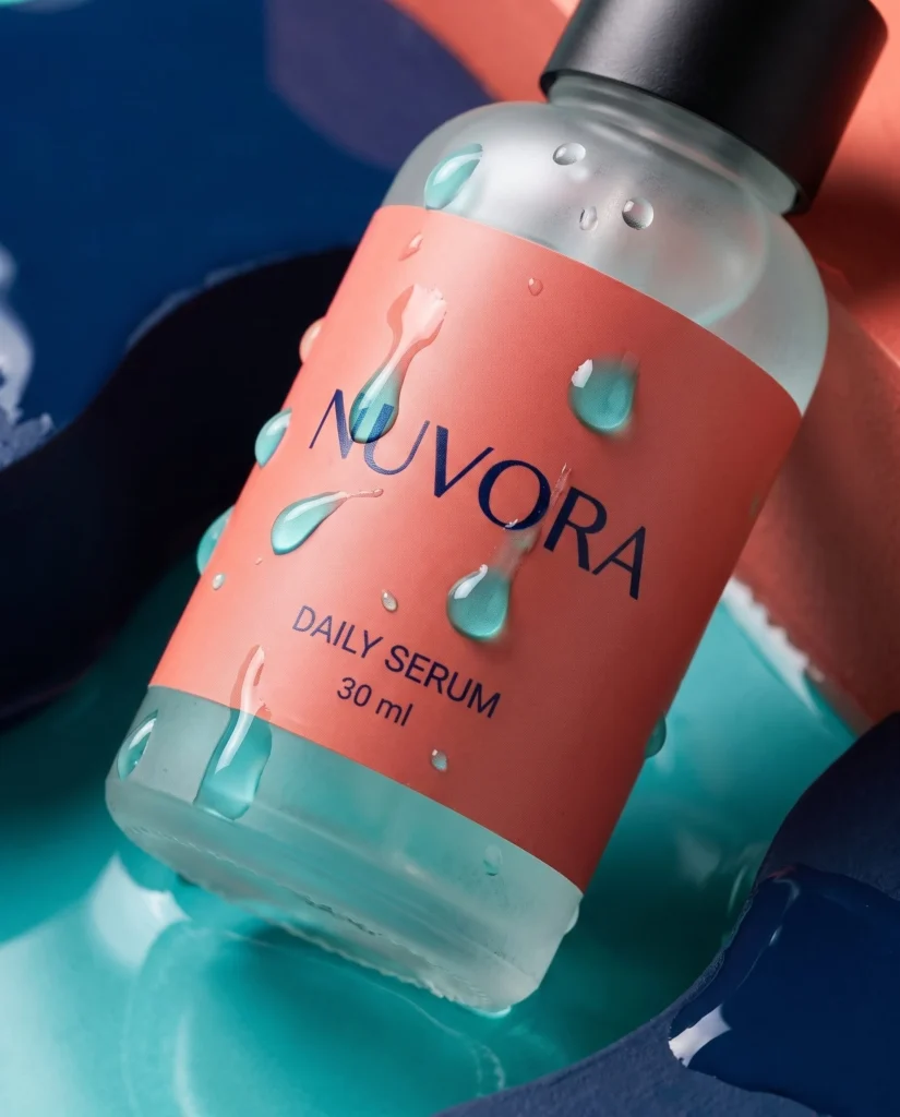 NUVORA coral-label serum bottle with water droplets