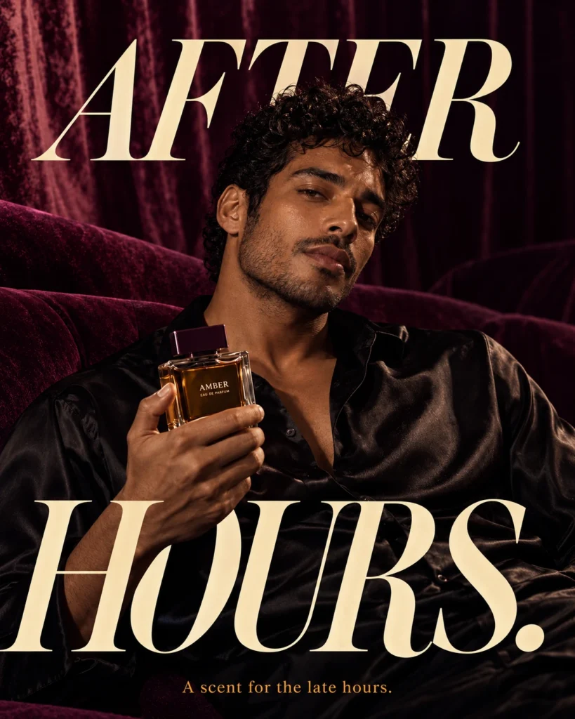 A man holding an amber fragrance bottle against plum velvet, with large ivory After Hours lettering behind him.