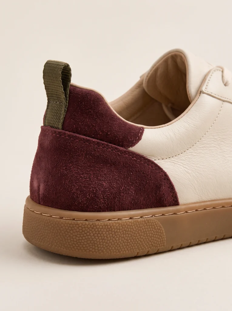 Sneaker heel detail with burgundy suede, ivory leather, olive pull loop and gum sole.