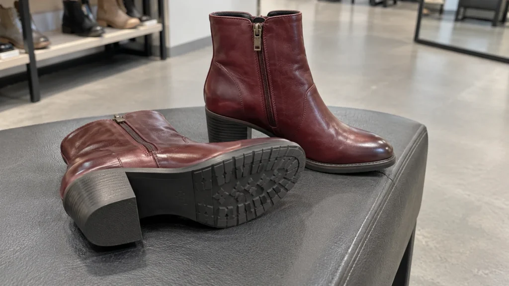 A pair of burgundy boots showing sole construction and side detail.